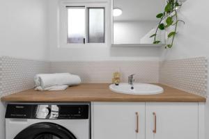 Un baño con lavabo y lavadora. en Tropicana Boutique Hotel - 2, en Cairns North