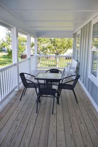 un patio avec une table et des chaises sur un porche dans l'établissement 4BR Soundfront cottage Private Dock Fishing, à Davis