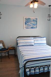 a bed in a bedroom with a ceiling fan at 2BR Cozy Cottage Private Dock in Davis +7 photos