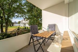 a balcony with a wooden table and two chairs at Strandschloss Wohnung 40 in Grömitz