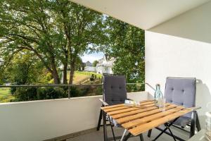 a balcony with a wooden table and two chairs at Strandschloss Wohnung 40 in Grömitz +28 photos