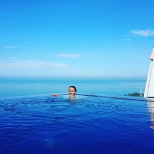 a woman in a swimming pool in the ocean at Rara Villas Lombok in Senggigi 