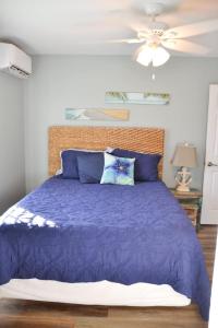 a bedroom with a purple bed with a ceiling fan at Cozy 3BR Cottage Fishing Private Dock Boating in Davis