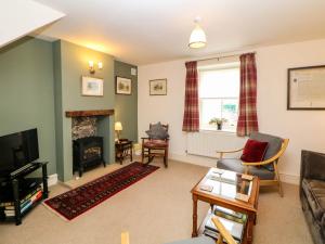 a living room with a couch and a fireplace at Brookside Barn in Bradwell
