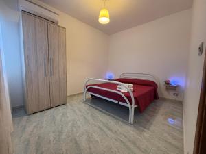 a bedroom with a bed with a red blanket at Lilly's house in Torre Santa Sabina