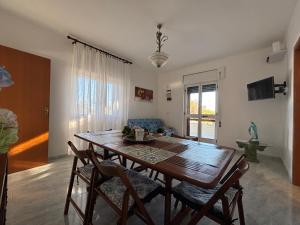 a dining room with a wooden table and chairs at Lilly's house in Torre Santa Sabina