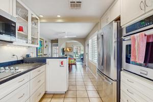 a kitchen with white cabinets and stainless steel appliances at Mesquite Country Club Condo O64 - Permit # 4552 - 7 night minimum stay in Palm Springs
