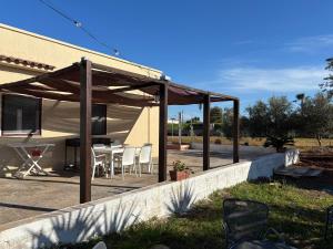 a pavilion with a table and chairs on a patio at Lilly's house in Torre Santa Sabina