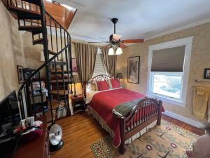 ein Schlafzimmer mit einem Bett und einer Wendeltreppe in der Unterkunft Historic Belmont House near the Downtown Mall in Charlottesville