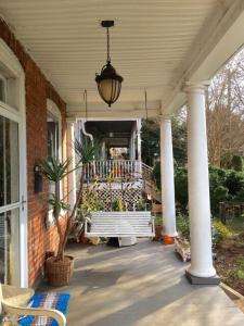 eine Veranda mit einer Bank auf einem Haus in der Unterkunft Historic Belmont House near the Downtown Mall in Charlottesville