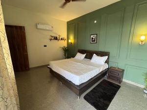 a bedroom with a bed and a green wall at Comfort stay in Beās