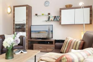a living room with a tv and a couch at Haus Baltic Ostseeidylle in Scharbeutz +27 photos