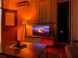 a living room with a television with a fire on it at Sunrise Apartment in Prishtina, Kosovo in Pristina