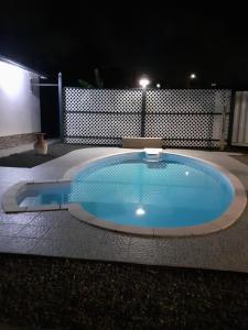 a large swimming pool in a yard at night at Hébergement T3 COSY WOUSIRE in Les Abymes +2 photos