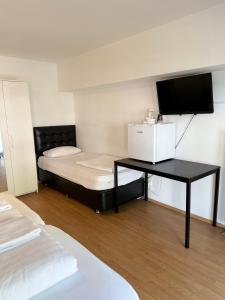 a room with a bed and a desk with a television at Hotel Garni Emir in Cologne +118 photos