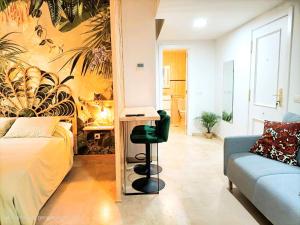 een slaapkamer met een bed en een bureau met een laptop bij NEW Tropic Malaka Home in Málaga