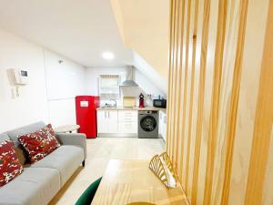 een woonkamer met een bank en een keuken bij NEW Tropic Malaka Home in Málaga +9 foto's