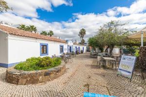 a cobblestone street with tables and chairs and buildings at Quinta Velha Oasis, Pool Resort in Cabanas de Tavira