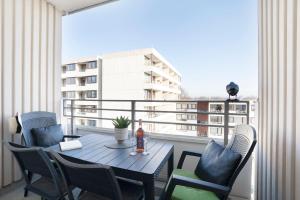 a table and chairs on a balcony with a view of a building at Ferienwohnanlage Leuchtturmweg StrandGeflüster in Kellenhusen +42 photos