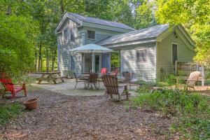 a house with a table and chairs and an umbrella at Walking distance to Lake Michigan! Cozy Cottage in Fennville