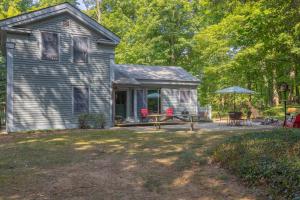 a small house with a picnic table in the yard at Walking distance to Lake Michigan! Cozy Cottage in Fennville +21 photos