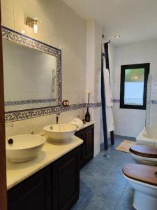 Un baño con dos lavabos y un espejo grande. en CASA do REMO, en Palmeira