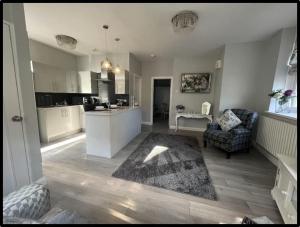 a kitchen and living room with a couch and a table at Coastal Cwtch in Moffat