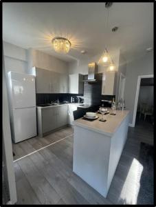 a kitchen with a white counter and a refrigerator at Coastal Cwtch in Moffat