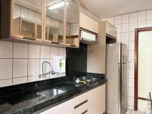 a kitchen with a sink and a refrigerator at ASA | Apto Funcional | Próx. Praia | Centro BC in Balneário Camboriú