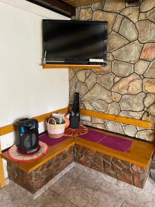 a television on top of a stone wall at Cabana Monte Crai in Poşaga de Sus