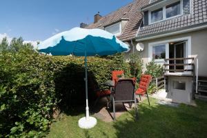 a table and chairs under an umbrella in a yard at Möwenschrei in Dahme +27 photos