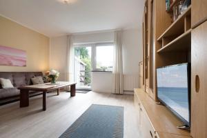 Una sala de estar con un televisor de pantalla plana grande. en Möwenschrei, en Dahme