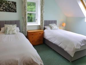 two beds in a bedroom with a window at Kirkwood - Real Farm Holidays & Experiences in Dalton