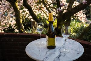 a bottle of wine and two wine glasses on a table at Huize De Kol in Holten +11 photos