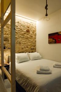 a bedroom with a bunk bed and a brick wall at Top Alti Studio Apartment in Ioannina