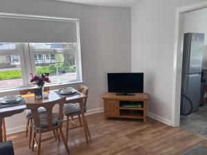 a living room with a table and a television at The South Promenade apartment in Newcastle