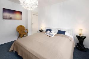 a bedroom with a large bed and a chandelier at Fliedergang 10 Wohnung 4 in Schönberger Strand