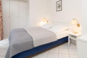 a white bedroom with a bed and a desk at Seepferdchen Stüble in Hansaland