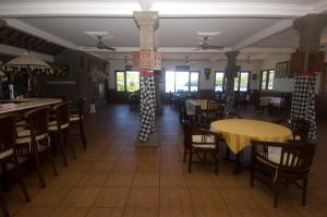 uma sala de jantar com mesas e cadeiras num restaurante em Puri Rai Hotel em Padangbai