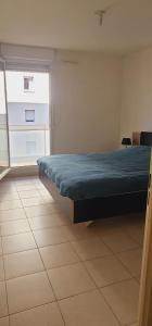 a bedroom with a bed with a blue blanket on it at Palais Omnisports, appart 4 personnes lumineux avec terrasse in Marseille