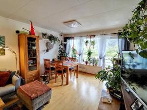 a living room with a table and chairs and a couch at Cozy room in a house with a garden on the island of Askøy, near Bergen in Askøy