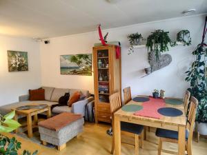 a living room with a table and a couch at Cozy room in a house with a garden on the island of Askøy, near Bergen in Askøy