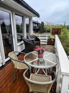 a patio with a table and chairs on a deck at Cozy room in a house with a garden on the island of Askøy, near Bergen in Askøy