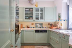 a kitchen with green cabinets and a sink at L'Oasis in Marseille