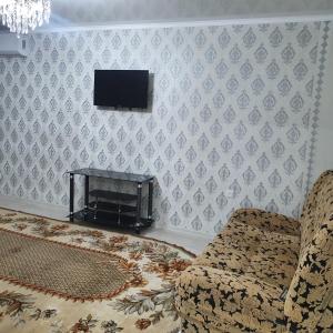 un soggiorno con un divano e una TV a parete di 2х ком квартира в Центре города ad Aqtöbe Altre 4 foto