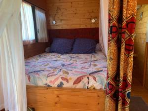 a bed in a wooden cabin with a canopy at La roulotte de Plajoulet in Mirepoix