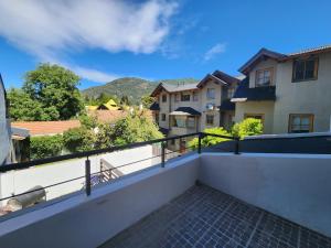 a balcony with a view of some buildings at Ruka 7- Andarlibre in San Martín de los Andes