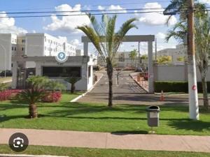 a view of a building with palm trees and a street at Ape Buritis, á 5 minutos do Aeroporto in Várzea Grande