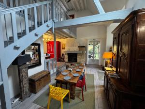 a dining room with a table and a staircase at L'Etincelle villa 14 pers, piscine jacuzzi, sauna in Saint-Martin-des-Champs