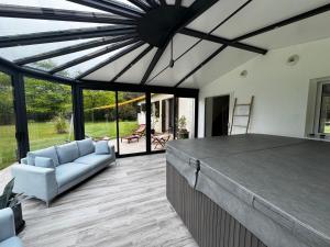 a living room with a large glass ceiling at L'Etincelle villa 14 pers, piscine jacuzzi, sauna in Saint-Martin-des-Champs
